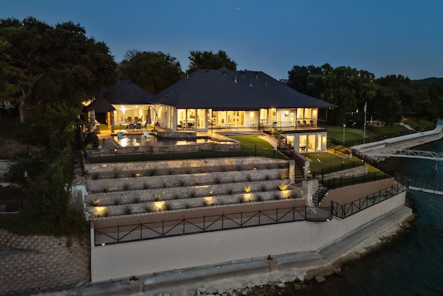 back house at dusk featuring a patio