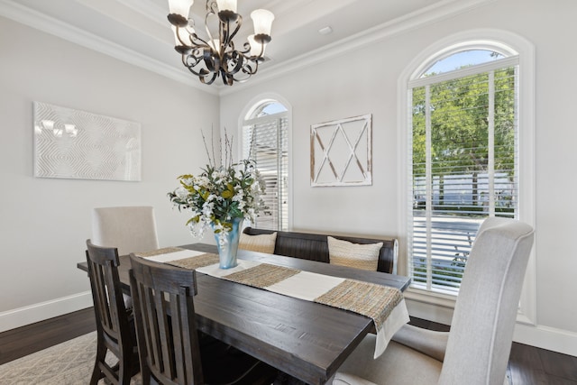 dining area with a notable chandelier, dark hardwood / wood-style floors, and ornamental molding