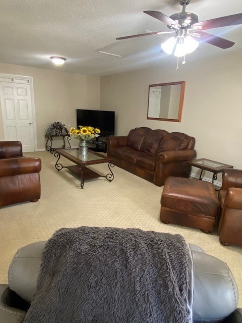 carpeted living room with ceiling fan