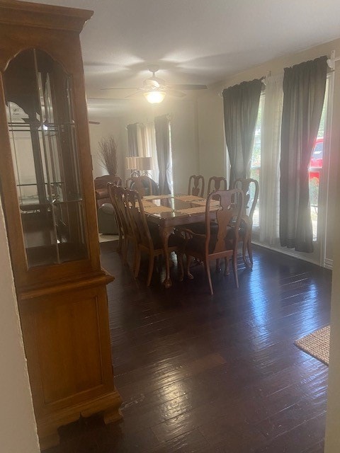 dining area with dark wood-type flooring and ceiling fan