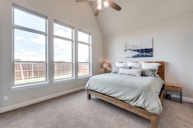 carpeted bedroom with high vaulted ceiling, baseboards, and a ceiling fan