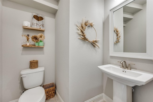 bathroom featuring toilet and baseboards