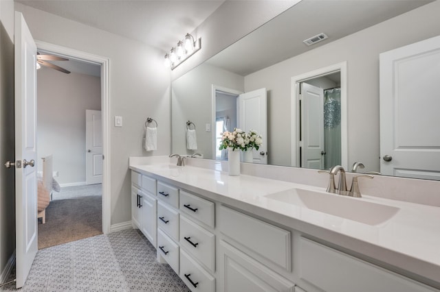 bathroom featuring double vanity, a sink, visible vents, and baseboards