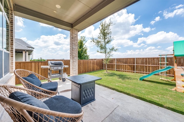 view of patio featuring a fenced backyard, a playground, and area for grilling