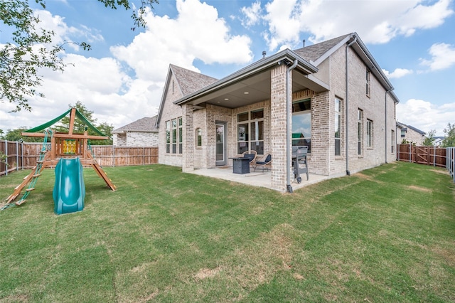 back of property with a yard, a fenced backyard, a patio, and a playground