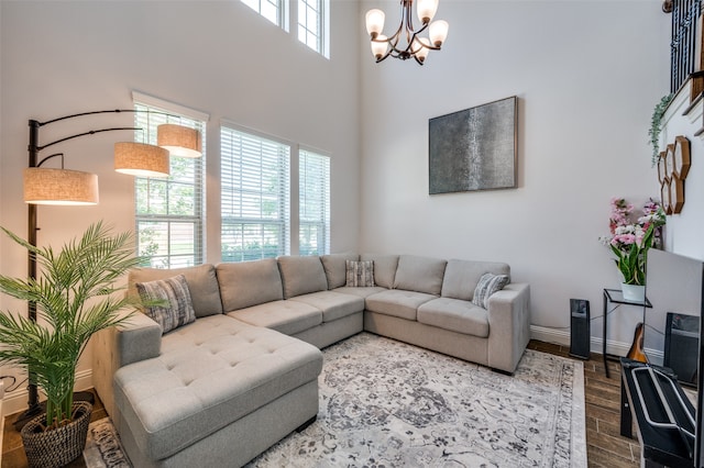 living room with hardwood / wood-style flooring, an inviting chandelier, and a high ceiling