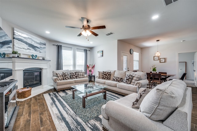 living room featuring ceiling fan and dark hardwood / wood-style floors