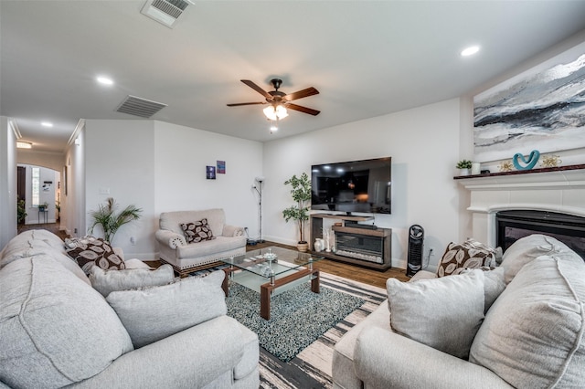 living area featuring recessed lighting, visible vents, a fireplace, and wood finished floors