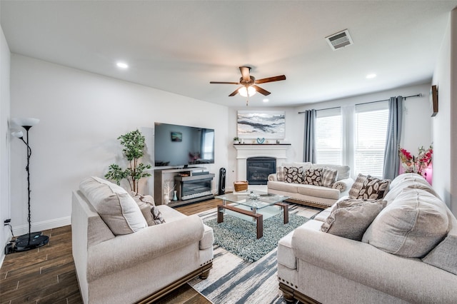 living room with recessed lighting, wood finished floors, visible vents, baseboards, and a glass covered fireplace