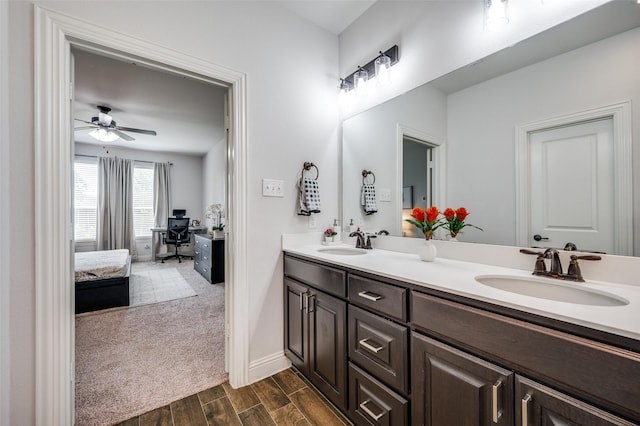 ensuite bathroom with wood tiled floor, a sink, ensuite bath, and double vanity