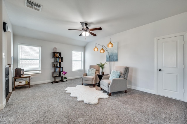 living area featuring baseboards, visible vents, ceiling fan, and carpet flooring