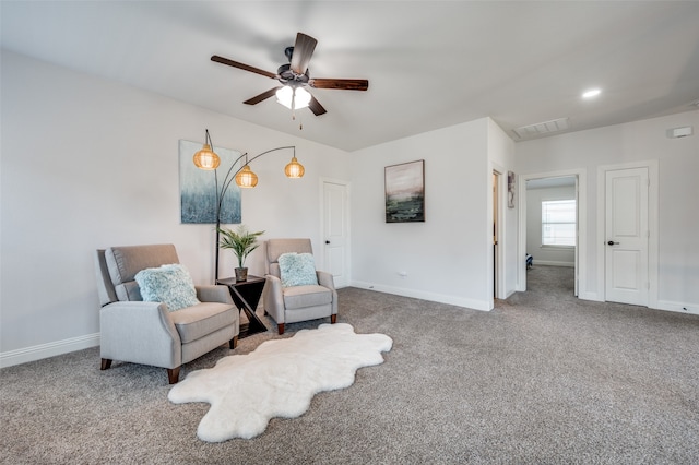 living area with ceiling fan and carpet flooring