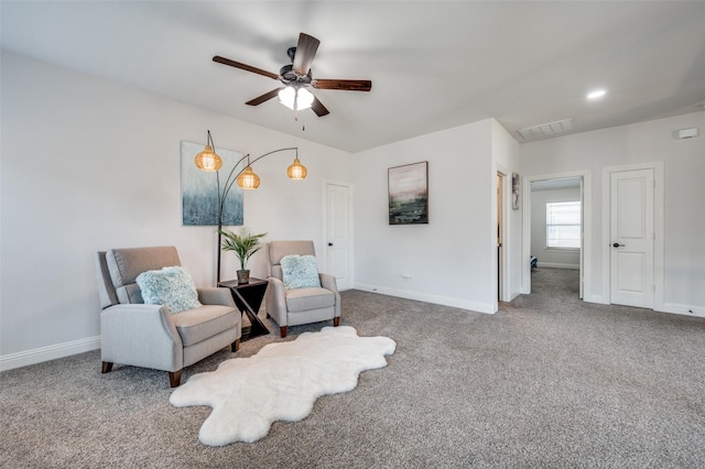 living area with ceiling fan, carpet flooring, visible vents, and baseboards