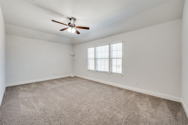 empty room with lofted ceiling, ceiling fan, and carpet floors