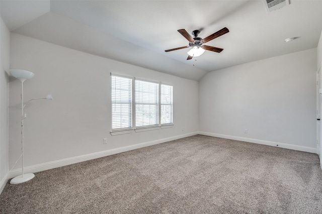 carpeted empty room featuring vaulted ceiling, ceiling fan, visible vents, and baseboards