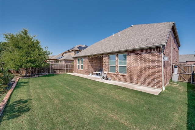 rear view of property with a yard and a patio