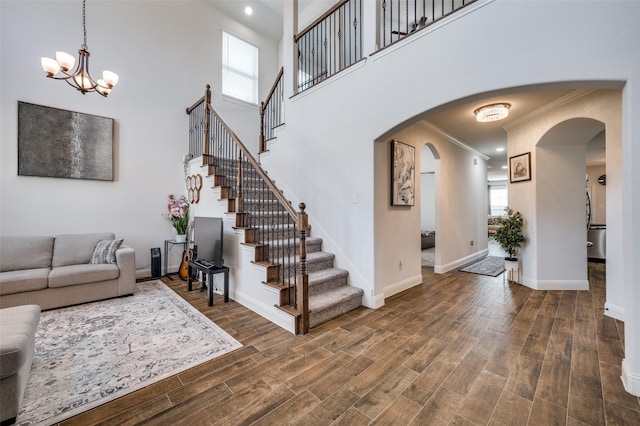 living room with baseboards, arched walkways, wood finished floors, and ornamental molding