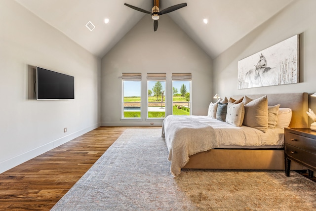 bedroom with ceiling fan, hardwood / wood-style floors, and high vaulted ceiling