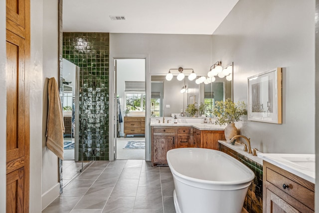 bathroom with a tub to relax in, tile patterned flooring, and vanity