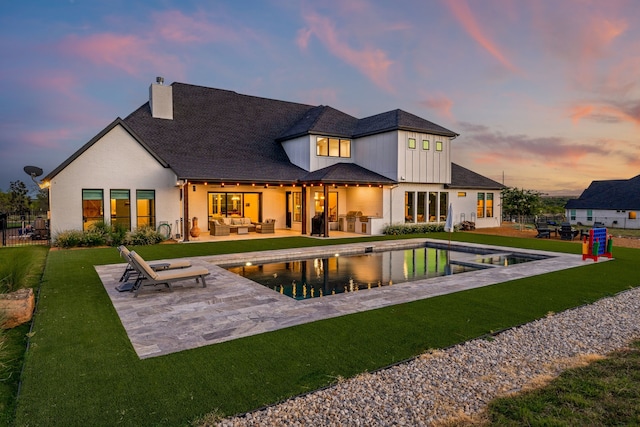 back house at dusk featuring area for grilling, a patio area, and an outdoor hangout area