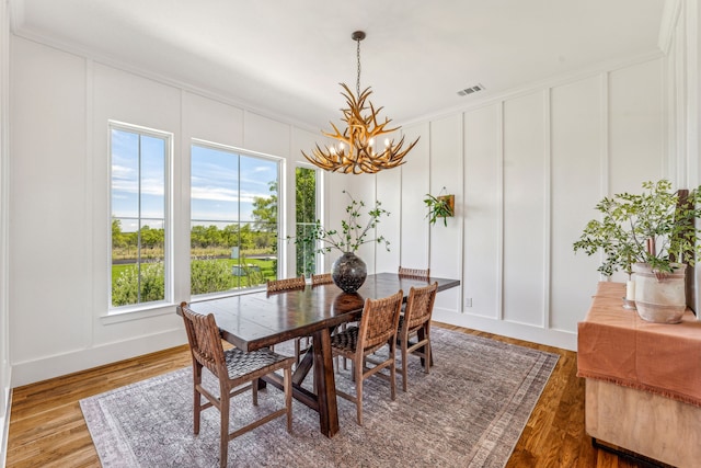 dining room featuring a chandelier, wood-type flooring, and ornamental molding