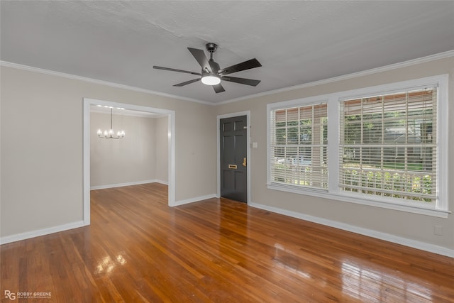 empty room with ceiling fan with notable chandelier, crown molding, and hardwood / wood-style flooring