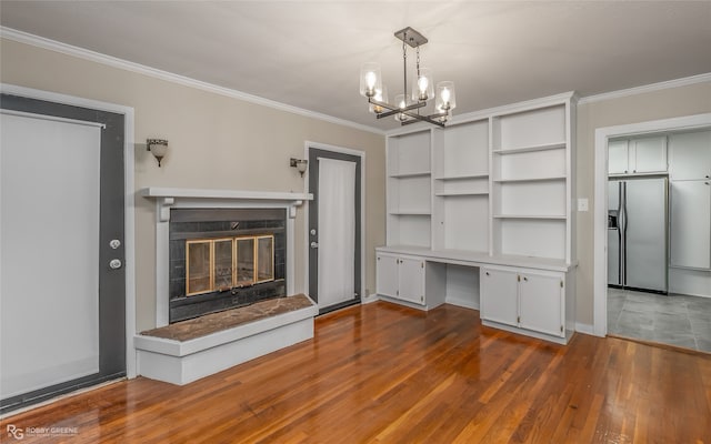 unfurnished living room with ornamental molding, wood-type flooring, and a chandelier