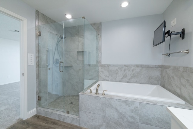 bathroom featuring separate shower and tub and wood-type flooring