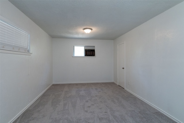 carpeted spare room featuring a textured ceiling