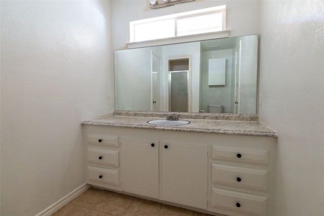 bathroom with vanity, toilet, walk in shower, and tile patterned flooring