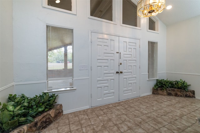 entryway with an inviting chandelier and high vaulted ceiling