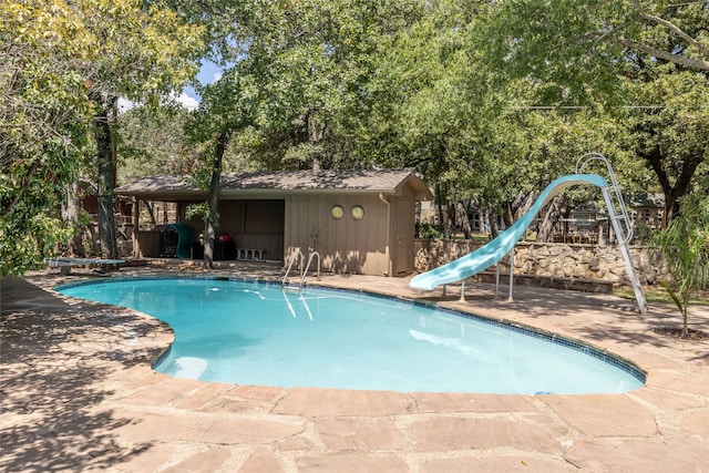 view of pool featuring a water slide and a patio area