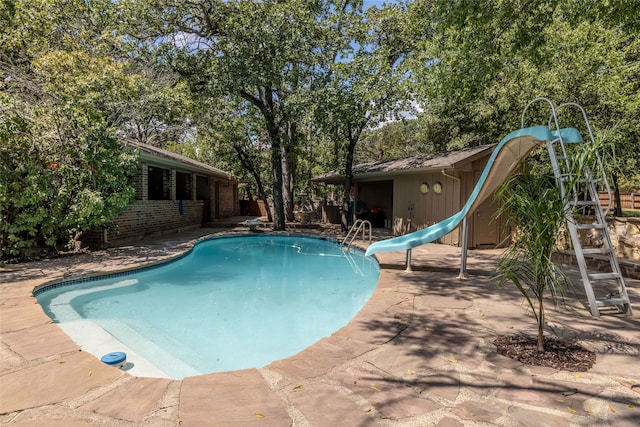 view of swimming pool featuring a water slide and a patio area