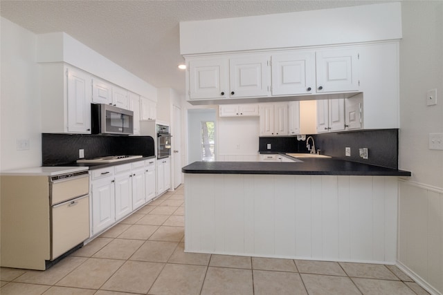 kitchen with white cabinetry, kitchen peninsula, and sink