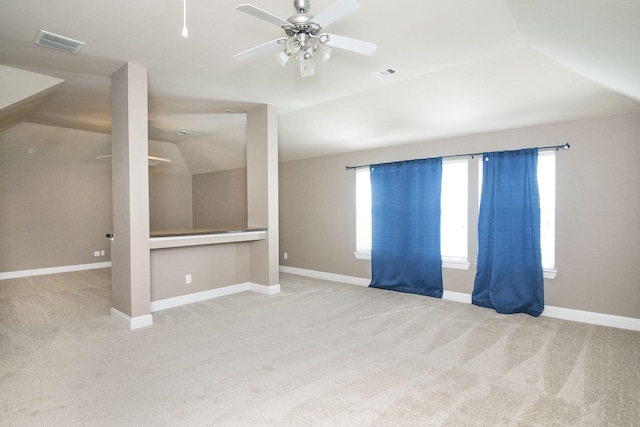 spare room featuring vaulted ceiling, carpet, and ceiling fan