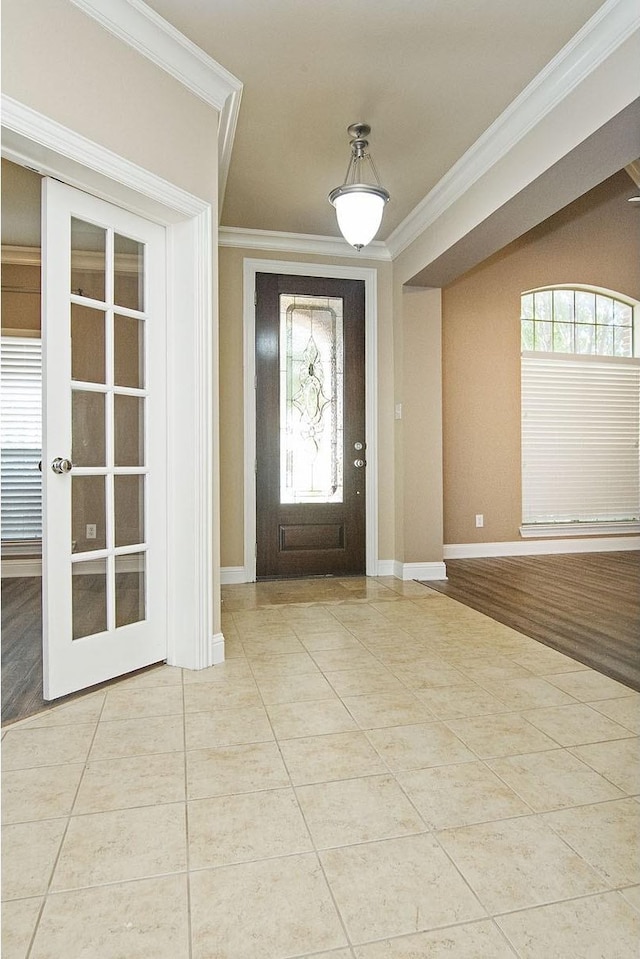 tiled foyer entrance with crown molding and french doors