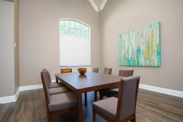 dining area with ornamental molding, dark hardwood / wood-style flooring, and lofted ceiling