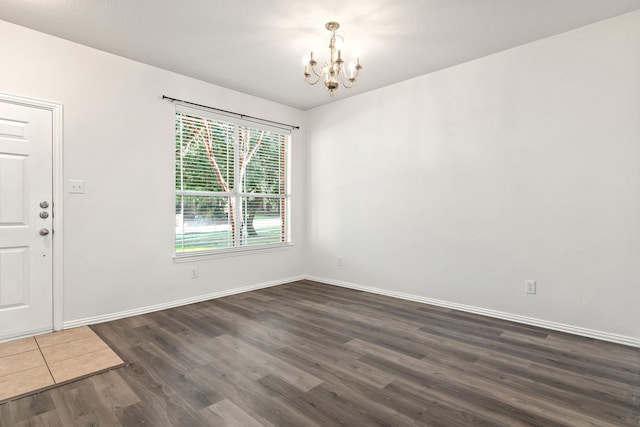 unfurnished room featuring dark hardwood / wood-style flooring and a chandelier