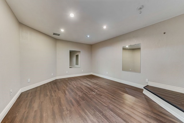 empty room with dark hardwood / wood-style flooring