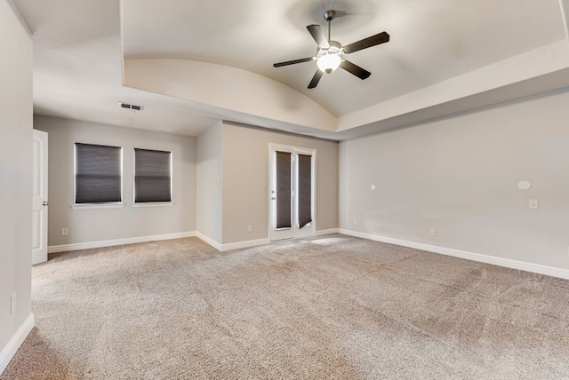 empty room with vaulted ceiling, ceiling fan, and carpet floors