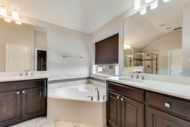 bathroom with tile patterned flooring, vanity, shower with separate bathtub, and vaulted ceiling