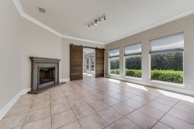 unfurnished living room featuring crown molding, a barn door, rail lighting, and light tile patterned flooring