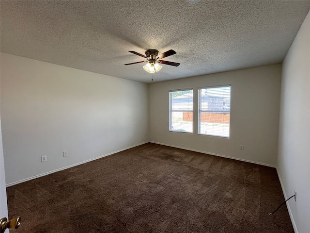 spare room featuring a textured ceiling, ceiling fan, and dark colored carpet