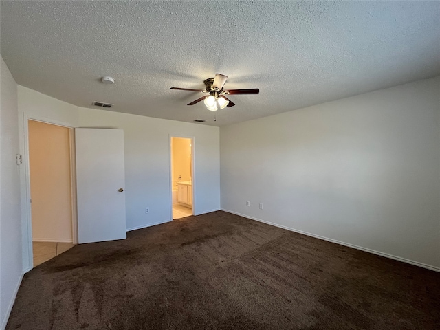 spare room featuring carpet flooring, ceiling fan, and a textured ceiling