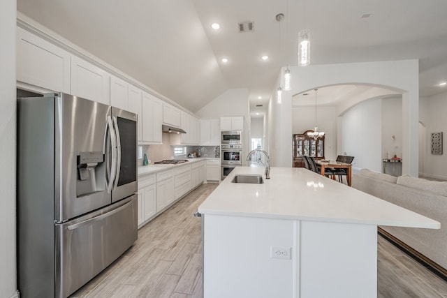 kitchen with white cabinets, stainless steel appliances, a kitchen island with sink, and sink