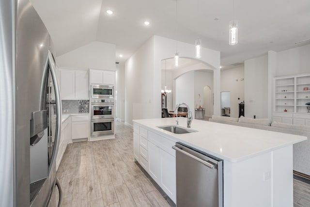 kitchen featuring a kitchen island with sink, stainless steel appliances, and white cabinets