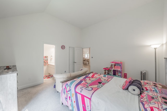 bedroom with vaulted ceiling, ensuite bathroom, and light colored carpet