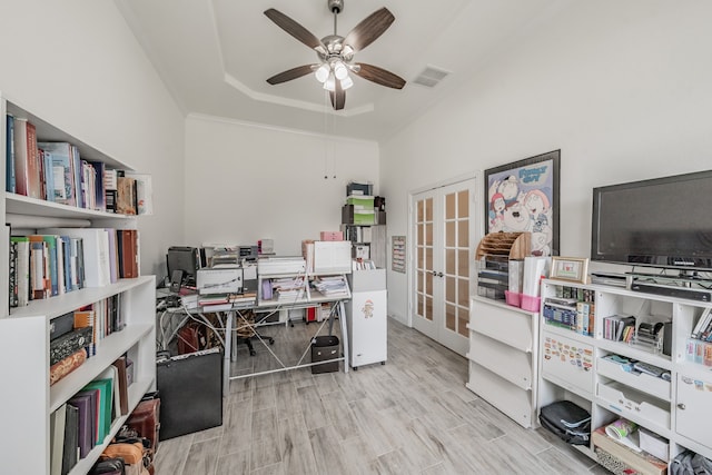 office featuring a raised ceiling, ceiling fan, french doors, and light hardwood / wood-style floors