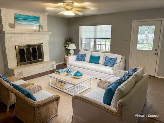 living room with ceiling fan and a fireplace