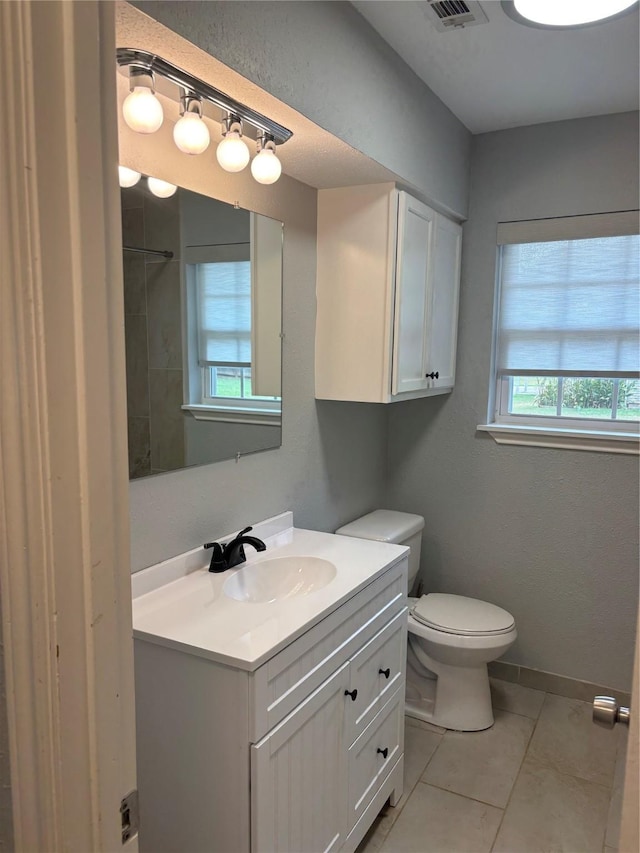 bathroom with vanity, toilet, and tile patterned flooring